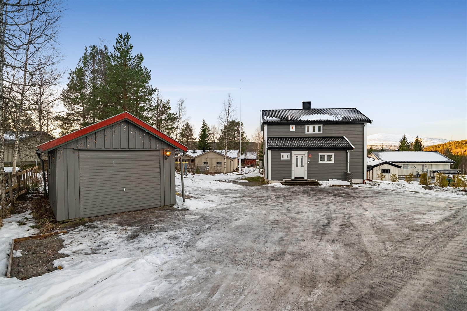 Tomten er romslig og forholdsvis flat opparbeidet med stor gårdsplass og hage med plen, busker og trær Galleribilde