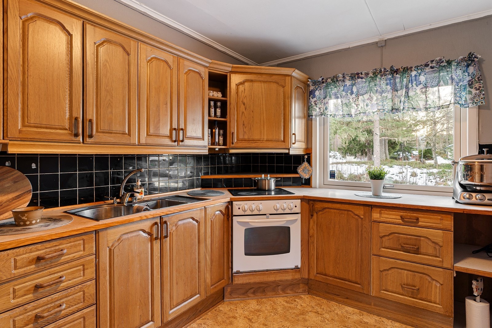 Kjøkkenet har innredning med folierte skrog med profilerte fronter og laminert benkeplate - Platetopp, stekeovn og ventilator Galleribilde