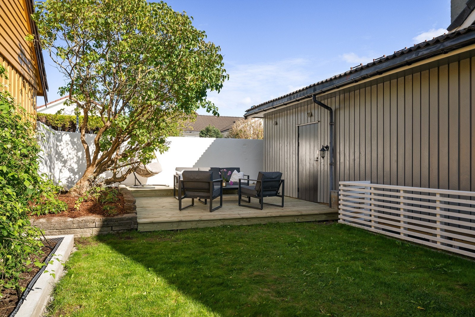 Markterrasse i bakkant av boligen med pent opparbeidet bed. Galleribilde