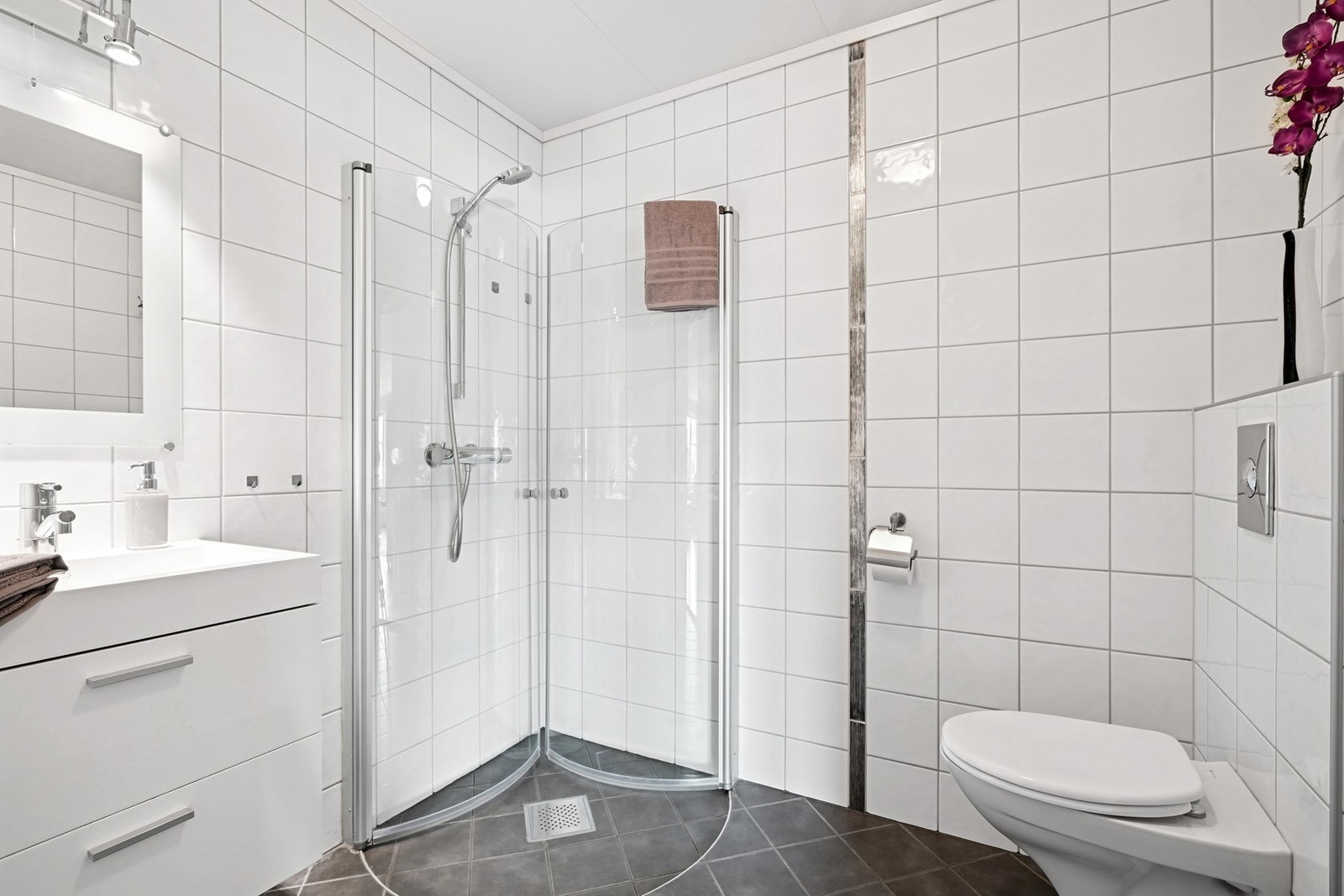 - dusjhjørne med glassdører og vegghengt toalett. Galleribilde