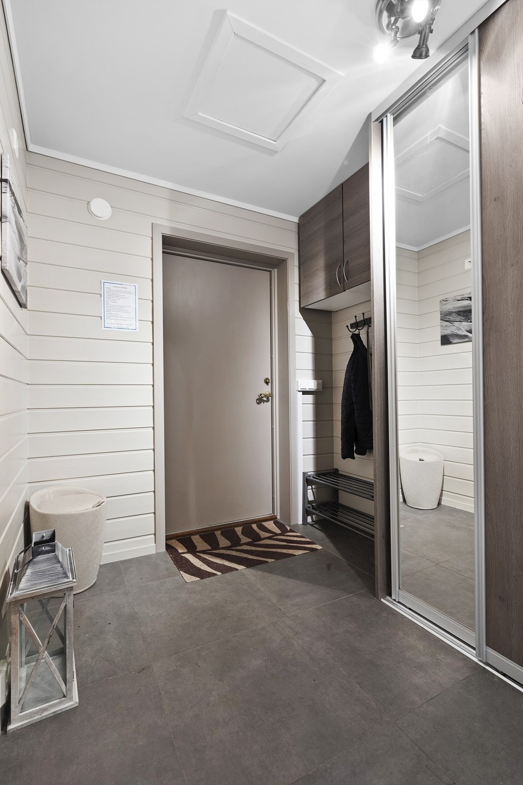 Velkommen inn i en lys entré med flislagt gulv med varmekabler. I entréen er det god plass til å henge fra seg yttertøy. Praktisk skyvedørsgarderobe med og oppbevaringsplass Galleribilde