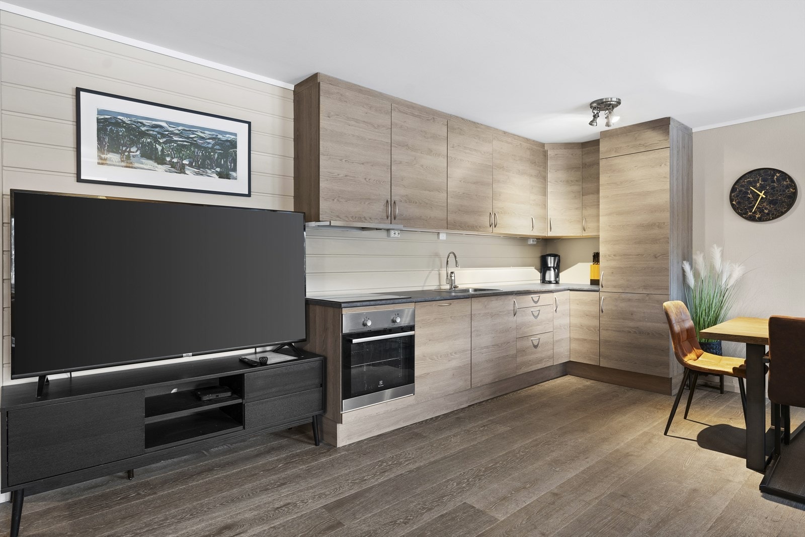 Innredningen har integrerte hvitevarer som oppvaskmaskin, stekeovn, platetopp og kjøl-/fryseskap Galleribilde