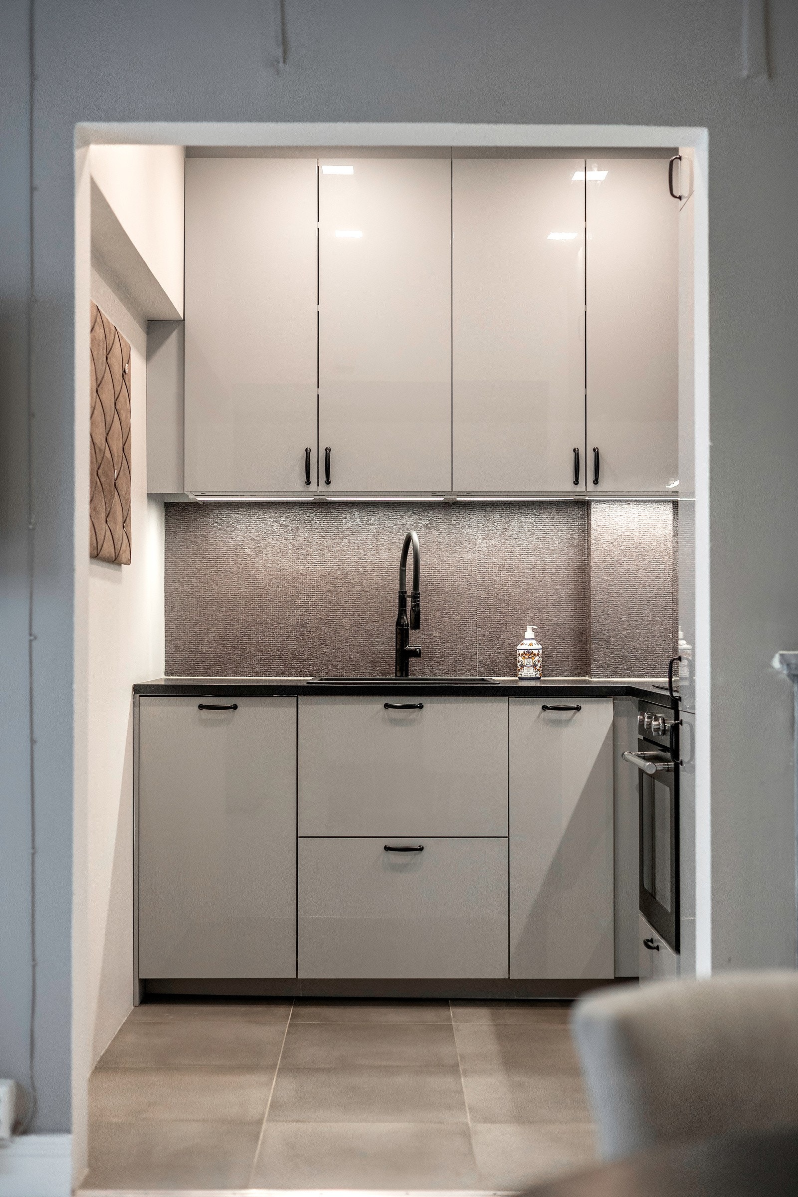 Moderne kjøkken fra 2021 med høyglanslaminerte fronter og mørklaminert benkeplate med nedfelt sort vaskekum. Galleribilde