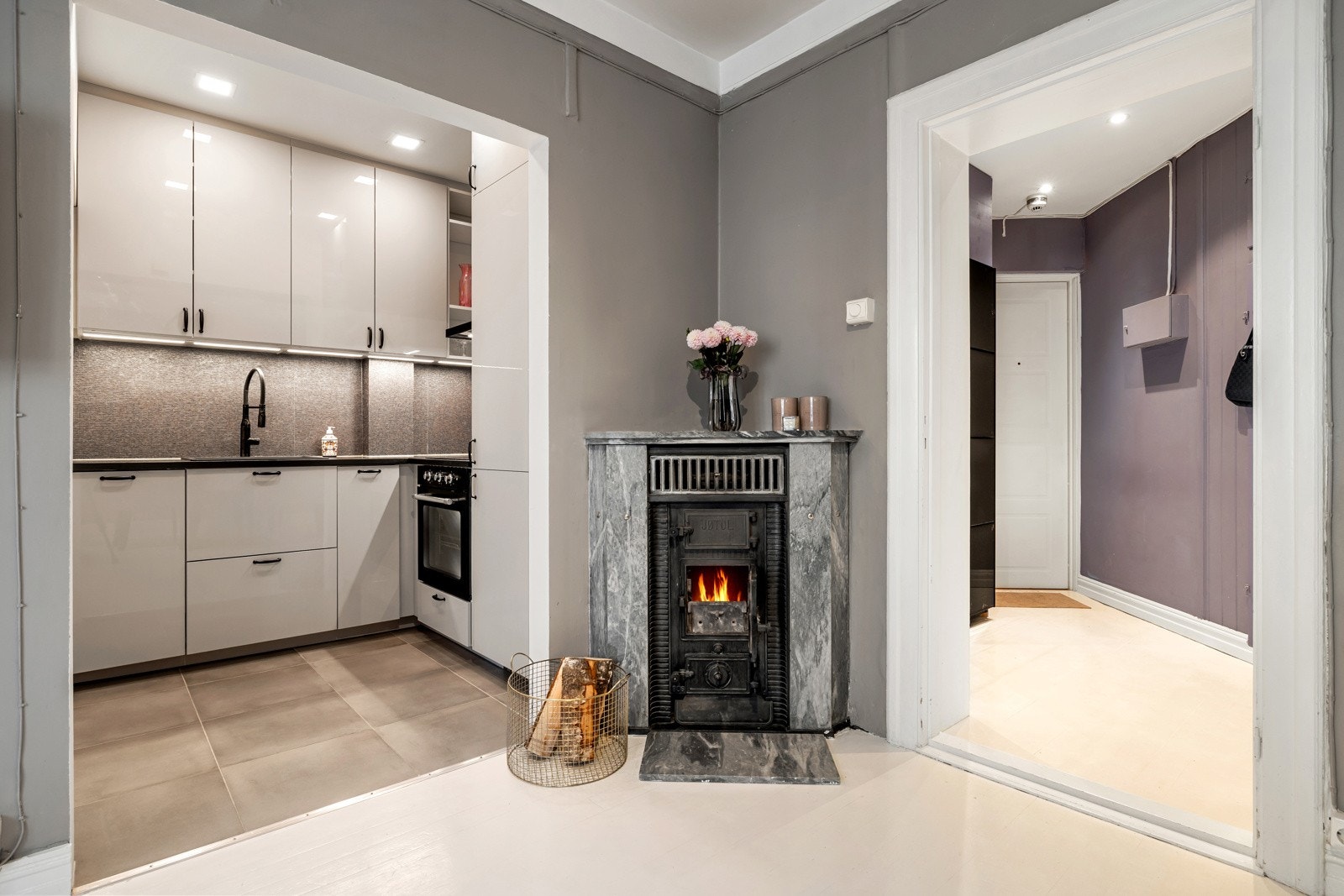 Den vakre peisen i klassisk stil gir leiligheten en ekstra sjarm og godt med varme. Galleribilde