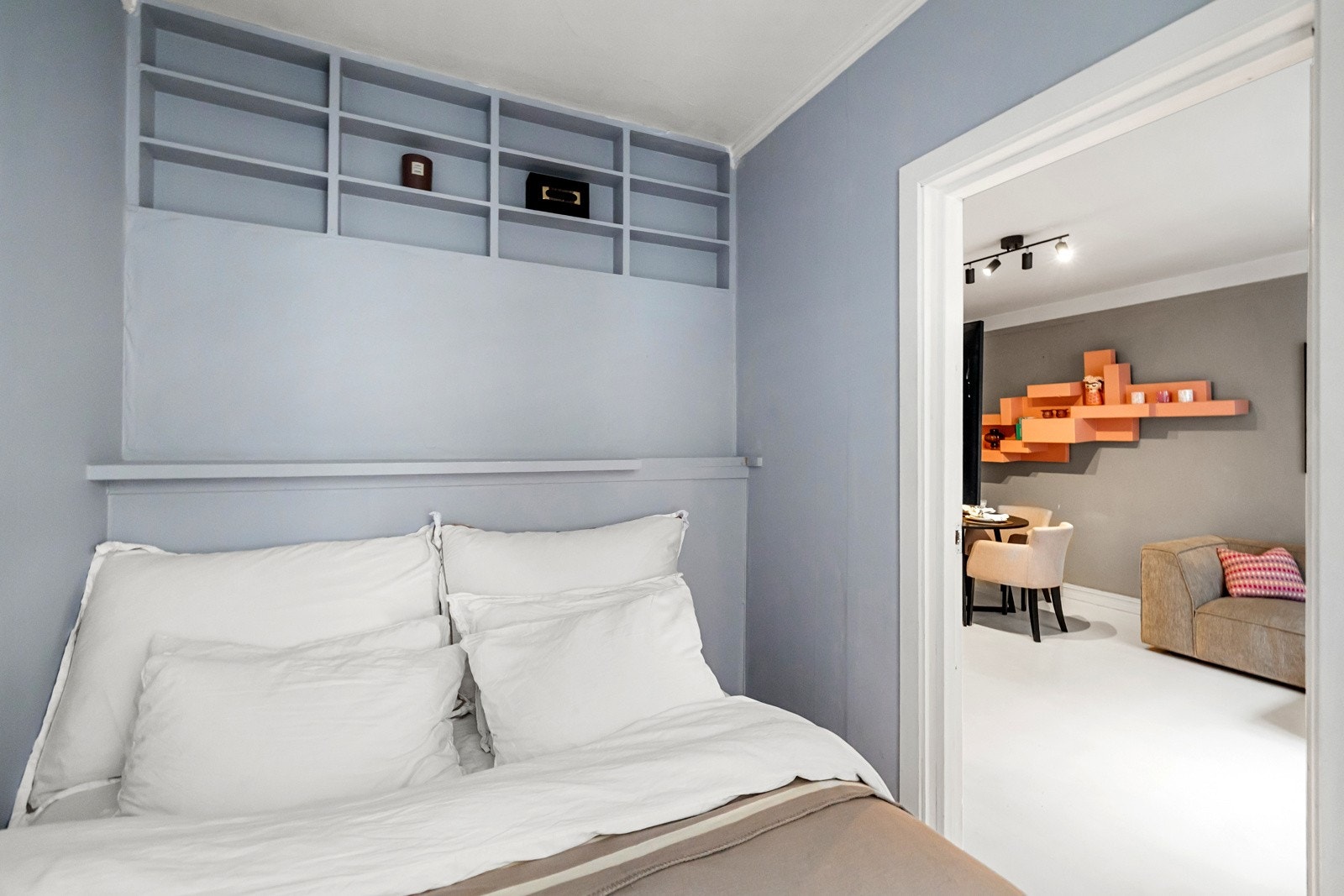 Praktiske plassbygde hyller og kant over sengen gir oppbevaringsplass til bøker, pynt mm. Galleribilde