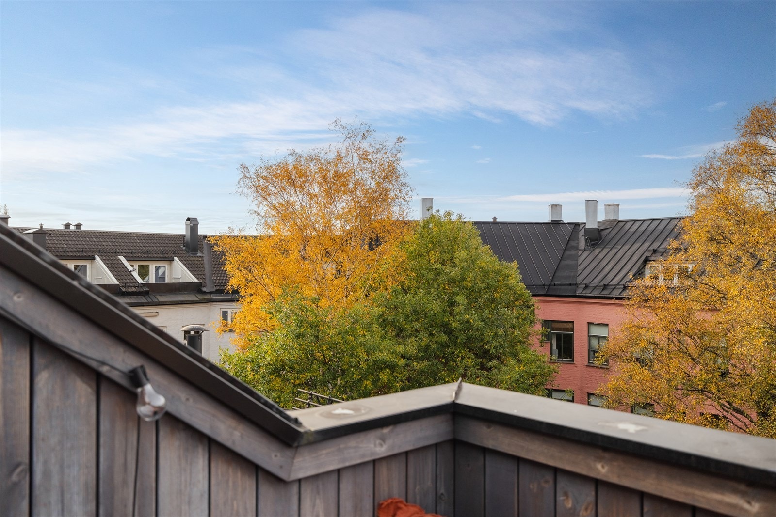 Hyggelig utsikt mot indre gårdsrom med store trær. Galleribilde