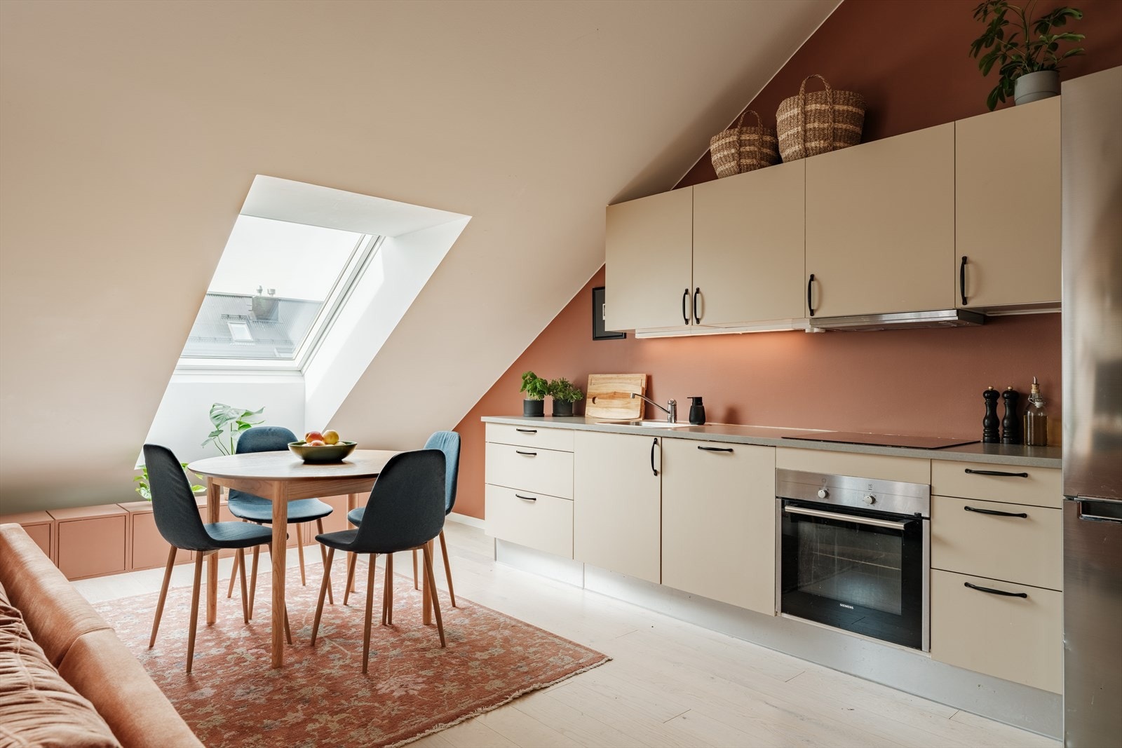 Kjøkkeninnredning med glatte fronter og laminat benkeplate med nedfelt kum i rustfritt stål. Galleribilde