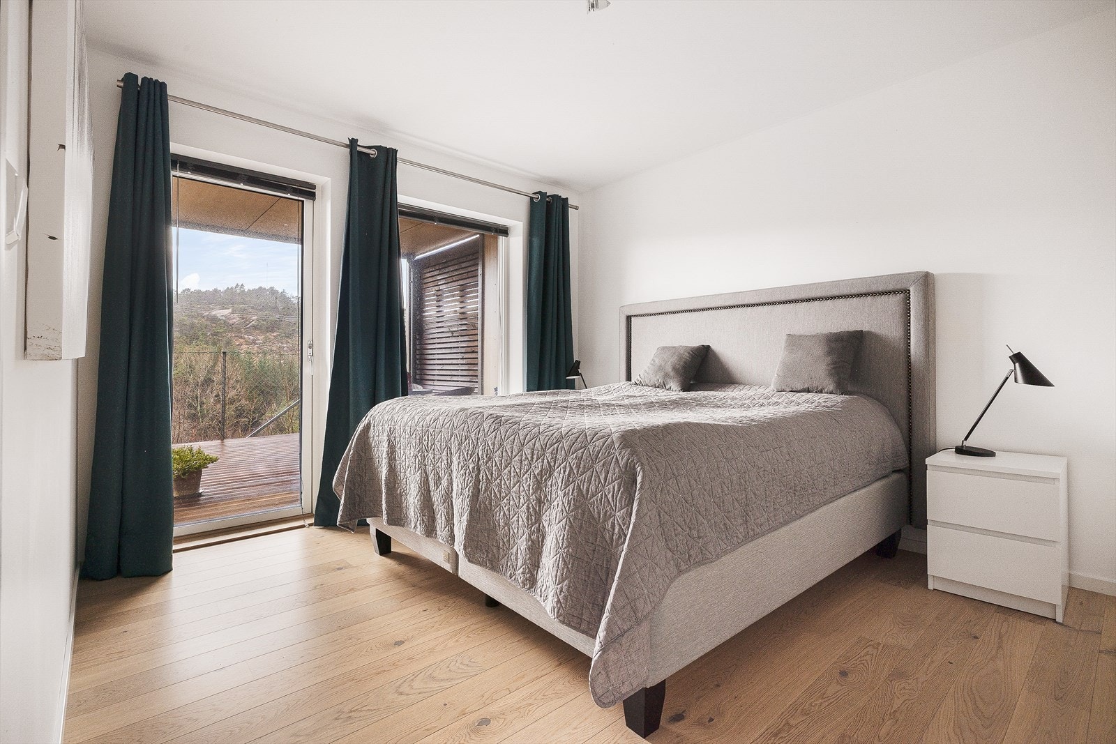 Lys og innbydende soverom med store vinduer som gir flott utsikt mot naturen. Galleribilde