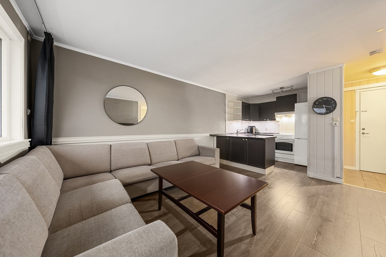 Fin sammenheng mellom stue og kjøkken, hvor rommet er malt i lyse og tidsriktige farger Galleribilde