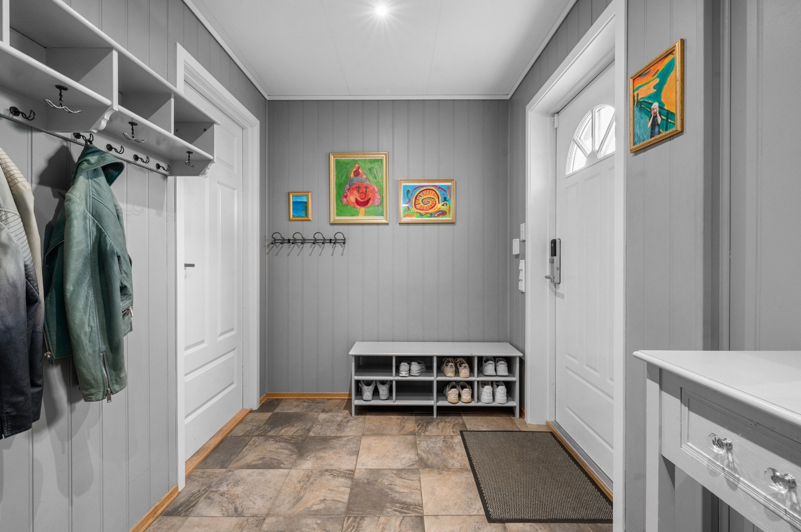 Romslig entré med flislagt gulv og god plass til oppbevaring i bod/garderobe. Galleribilde