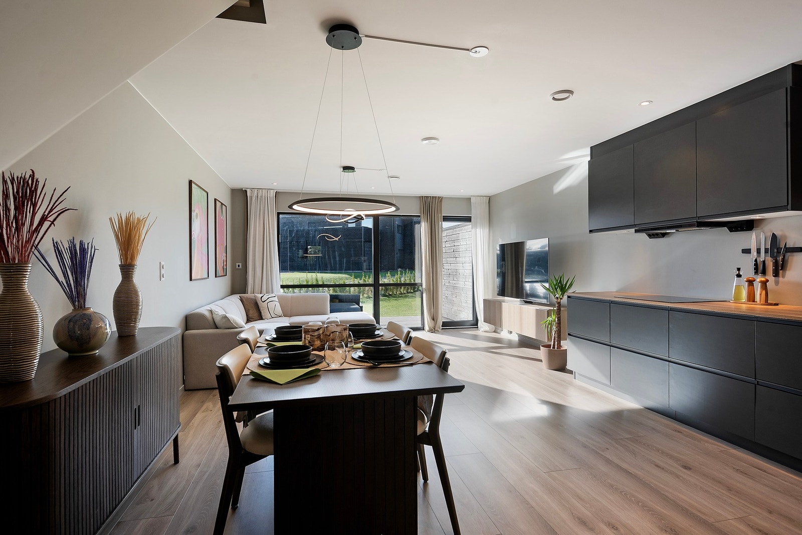 En bolig med store vindusflater og et åpent, innbydende oppholdsrom som skaper en lys og luftig atmosfære Galleribilde