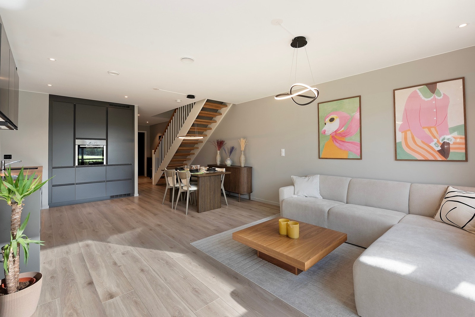 Stue og kjøkken ligger i en åpen og sosial løsning, med god plass til både spisebord og sofaområde - innbydende oppholdsrom for både hverdag og gjester Galleribilde