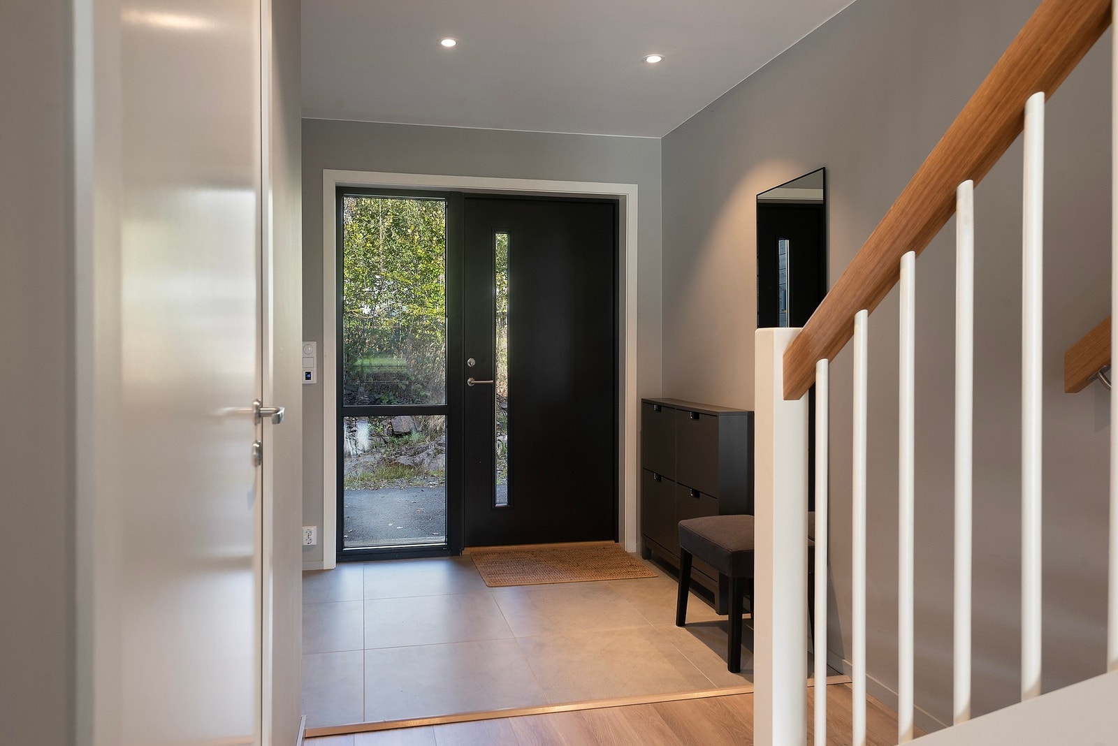 Innenfor døren finner du elegant flislagt entré med downlights i taket og plass til å sette inn garderobeskap Galleribilde