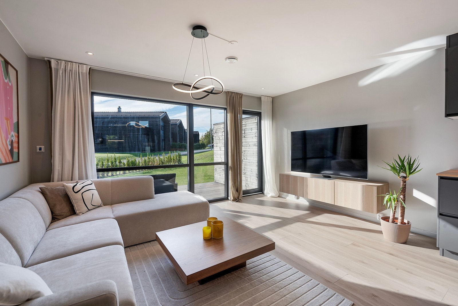 De store vindusflatene mot terrassen slipper inn rikelig med lys og gjør at terrassen føles som en naturlig forlengelse av stueområdet Galleribilde