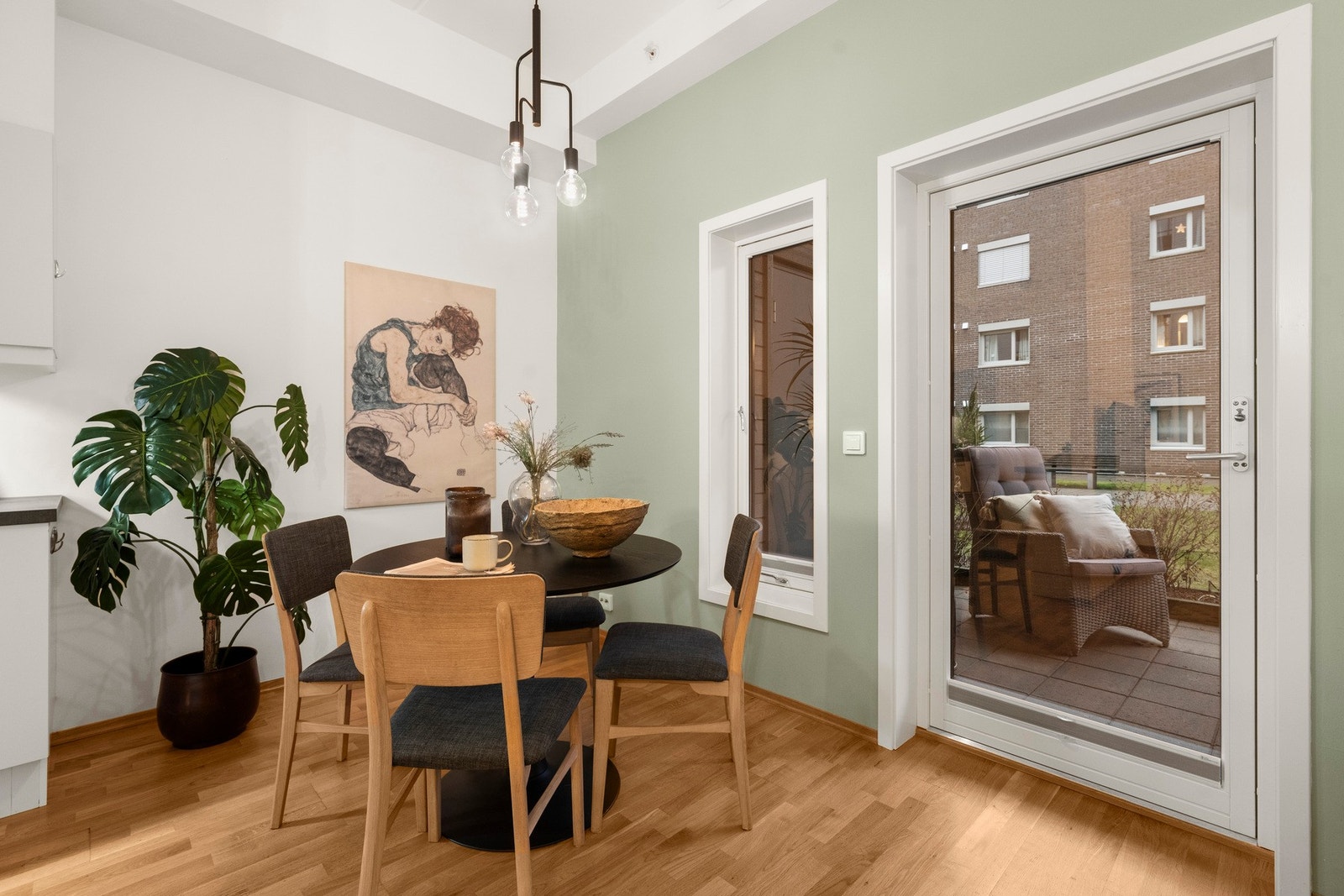 Med store vinduer som slipper inn naturlig lys, blir spisestuen et hyggelig samlingspunkt Galleribilde