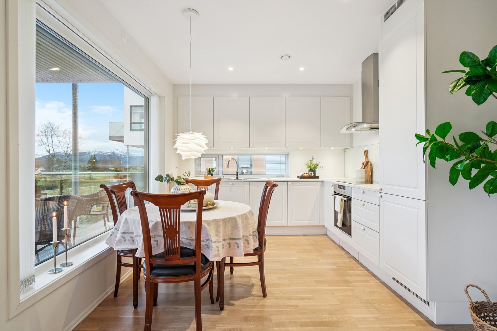 Flott kjøkkeninnredning fra HTH med hvite profilerte fronter og laminat benkeplate. Galleribilde