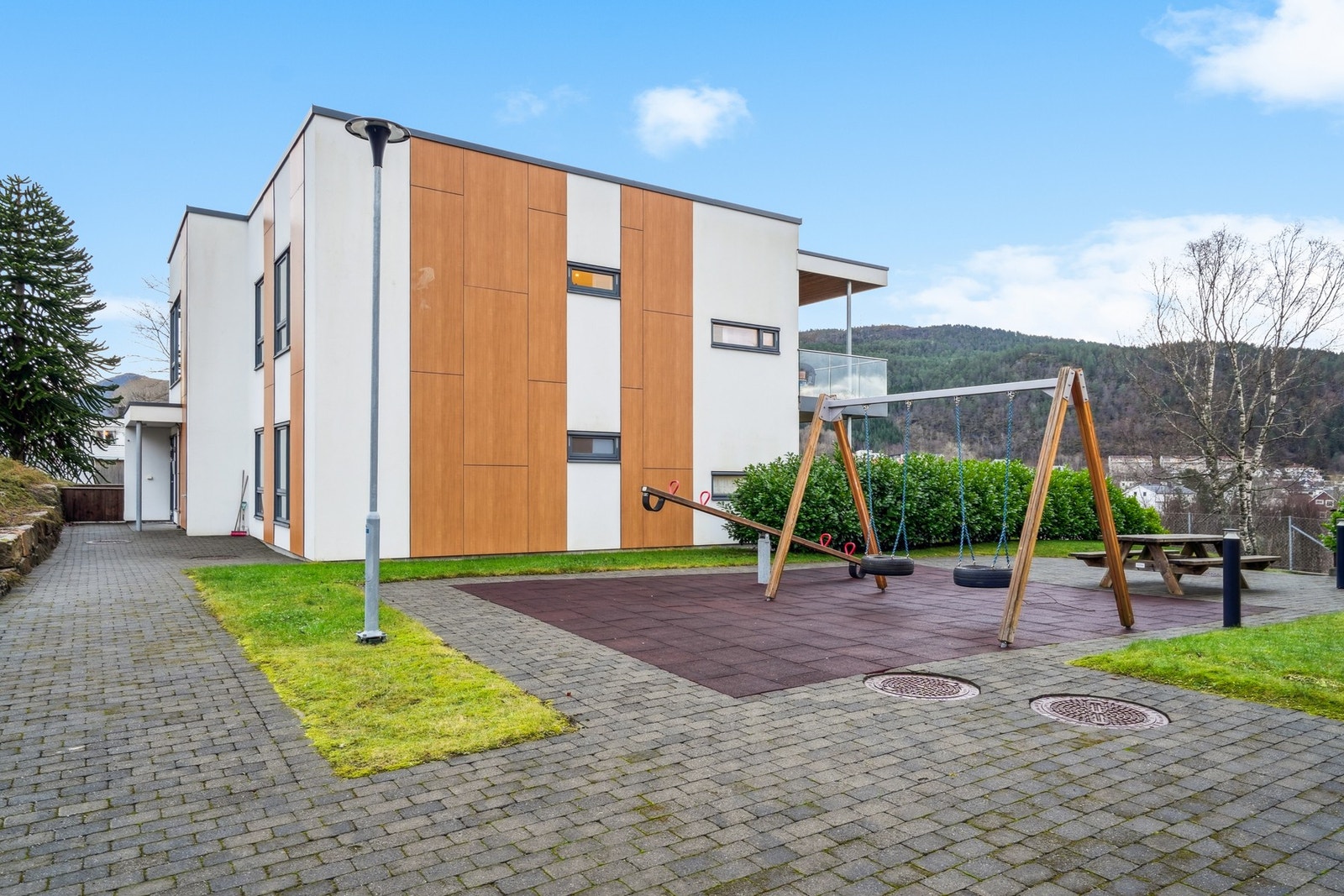 Pent opparbeide fellesareal med huskestativ og lekeapparater for de minste. Galleribilde