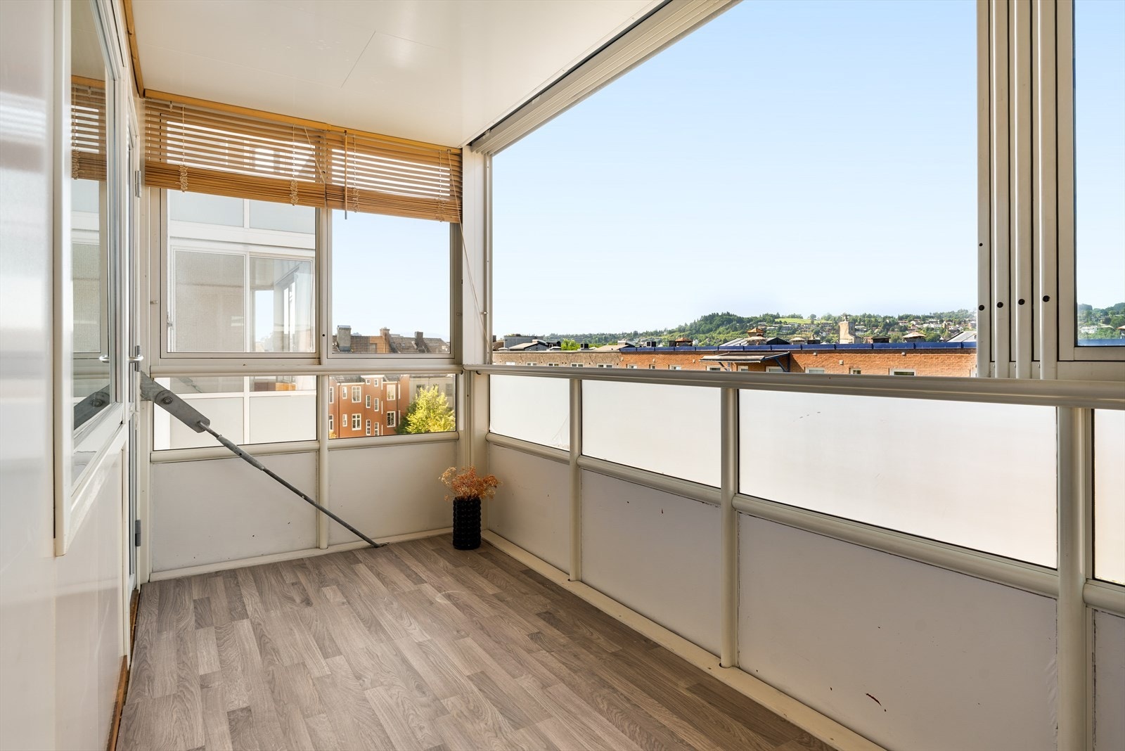 Fra stuen er det utgang til innglasset balkong med langstrakt utsikt og lang solgang på ettermiddag og kveld. Galleribilde