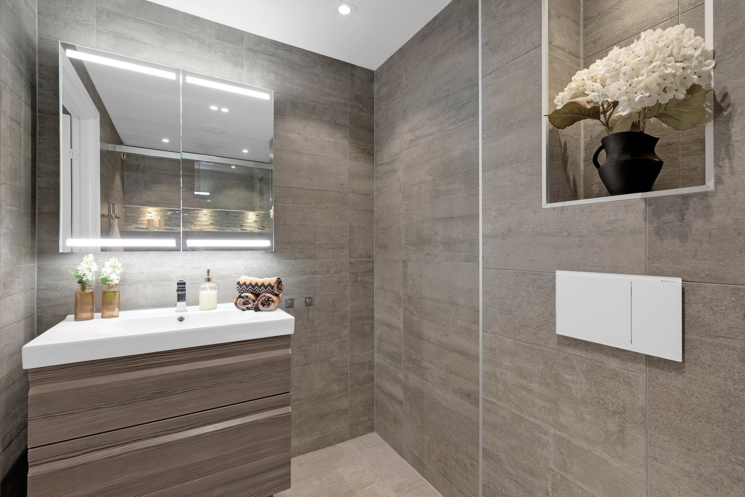 Rommet har innredning med nedfelt servant, veggmontert toalett og dusjvegger/hjørne. Galleribilde