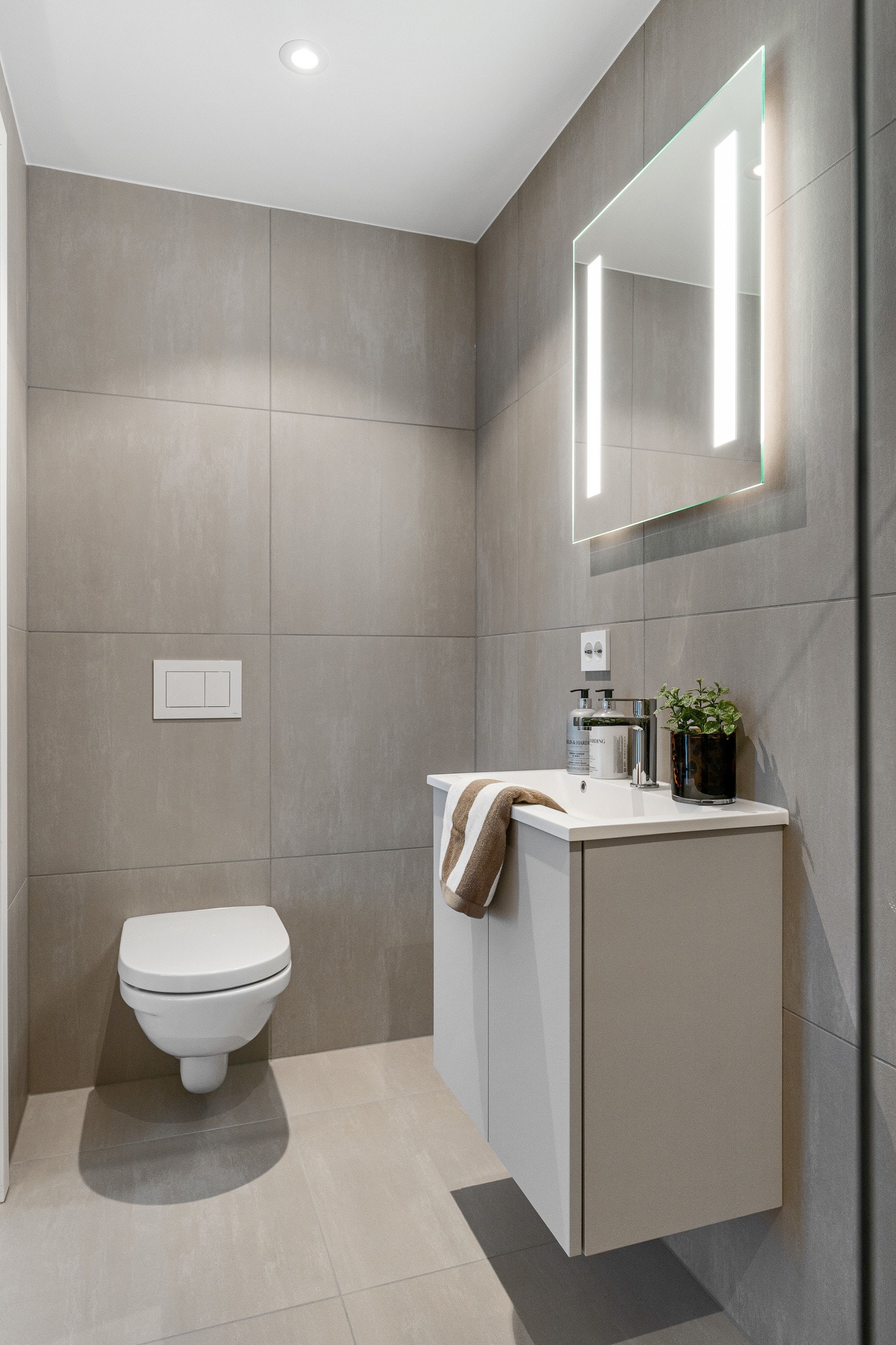 En-suite badet er innredet med toalett, dusjhjørne, servant med opplyst speil og downlights. Galleribilde