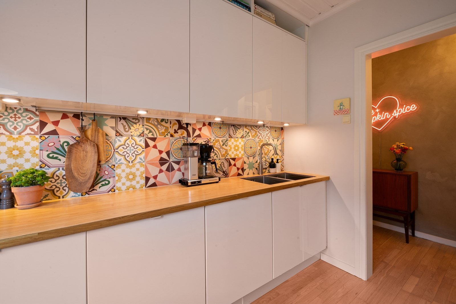 Kjøkkenet ble opprinnelig etablert i 2007 og har en stilren innredning med høyglans fronter og benkeplate med finert overflate. Rommet har fått flere oppgraderinger i perioden 2020-2024, inkludert deler av innredningen og hvitevarer. Galleribilde