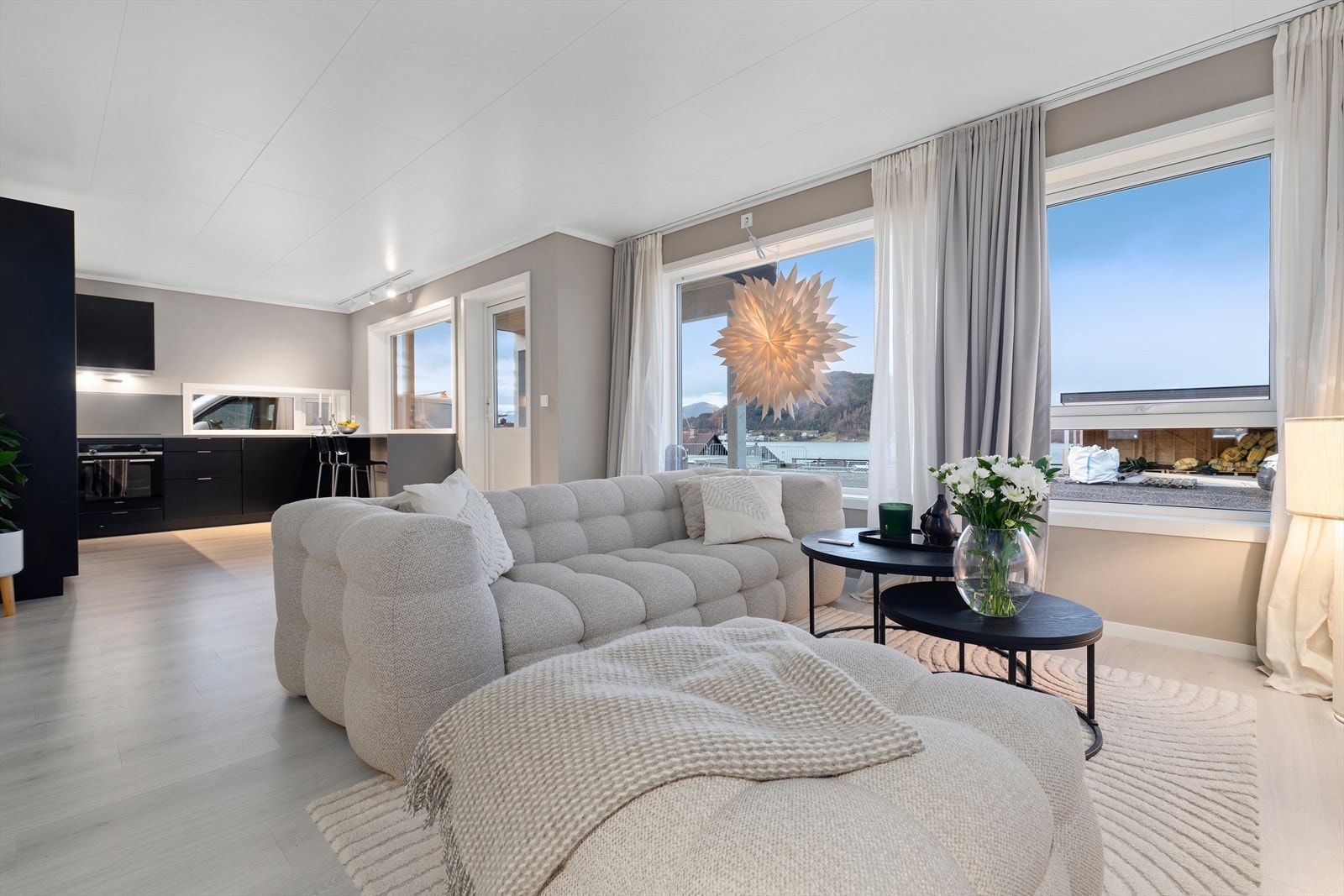 Lys og innbydende stue med store vindusflater Galleribilde