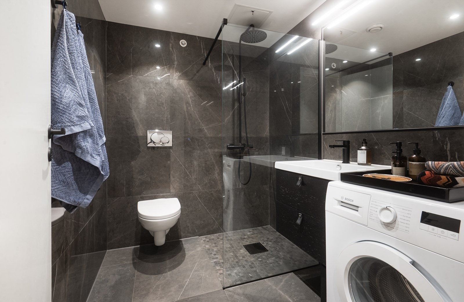 Moderne og innbydende bad med elegante, mørke fliser og varmekabler i gulv Galleribilde