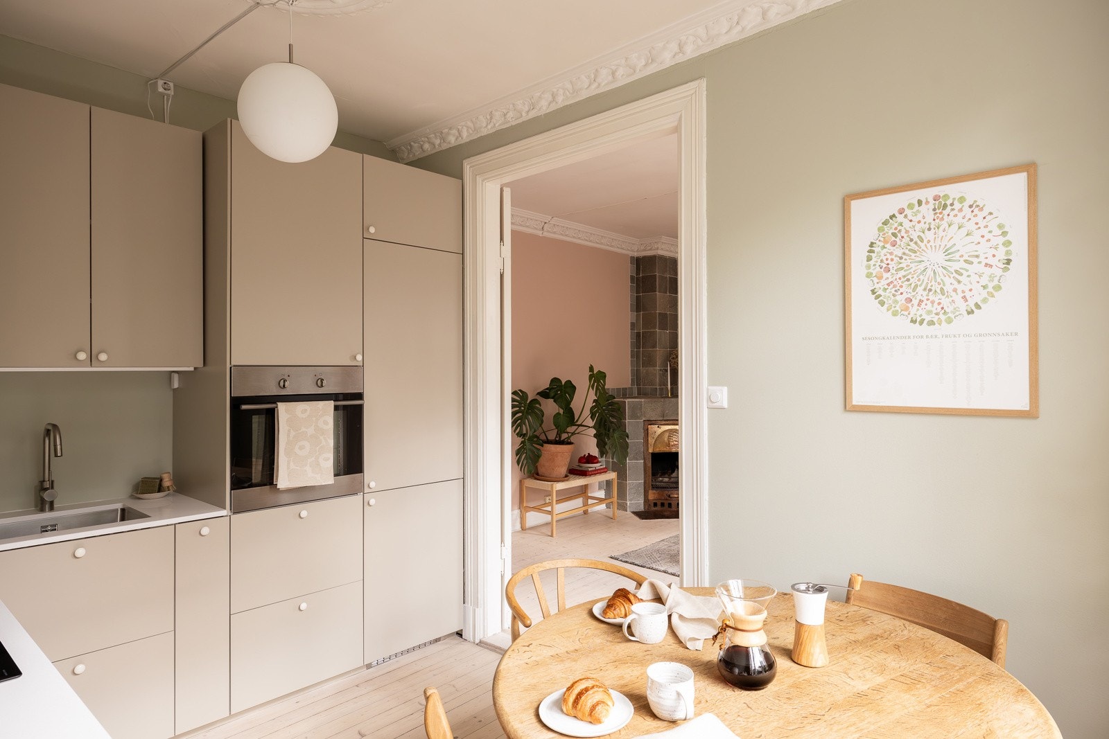 Integrerte hvitevarer som induksjonsplatetopp med ventilator, stekeovn, oppvaskmaskin og kjøle/fryseskap. Galleribilde