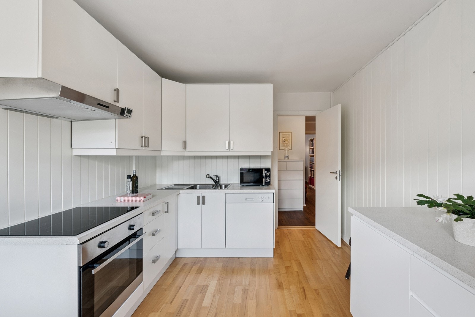 Kjøkkeninnredning med slette fabrikklakkerte fronter, laminat benkeplate, 1 1/2 oppvaskkum, ventilator og integrert stekeovn, koketopp og Galleribilde