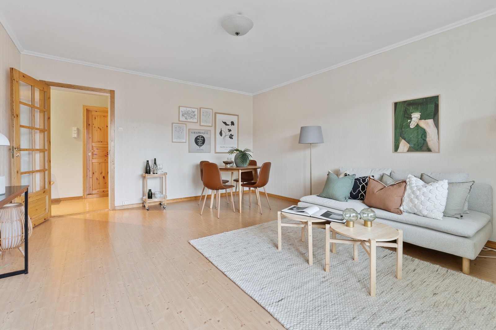 Stuen er holdt i en lys stil. Profilert dør med glass mellom stue og entré. Galleribilde