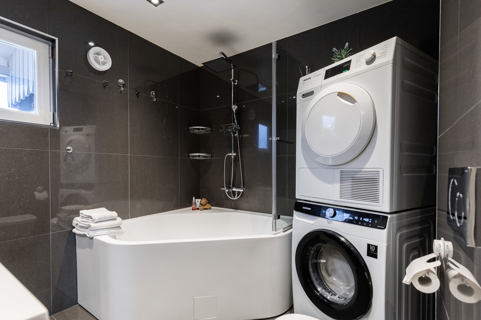 Her er det store, grå fliser på veggene, downlights i himlingen og lysegrå fliser på gulv med gulvvarme. Galleribilde