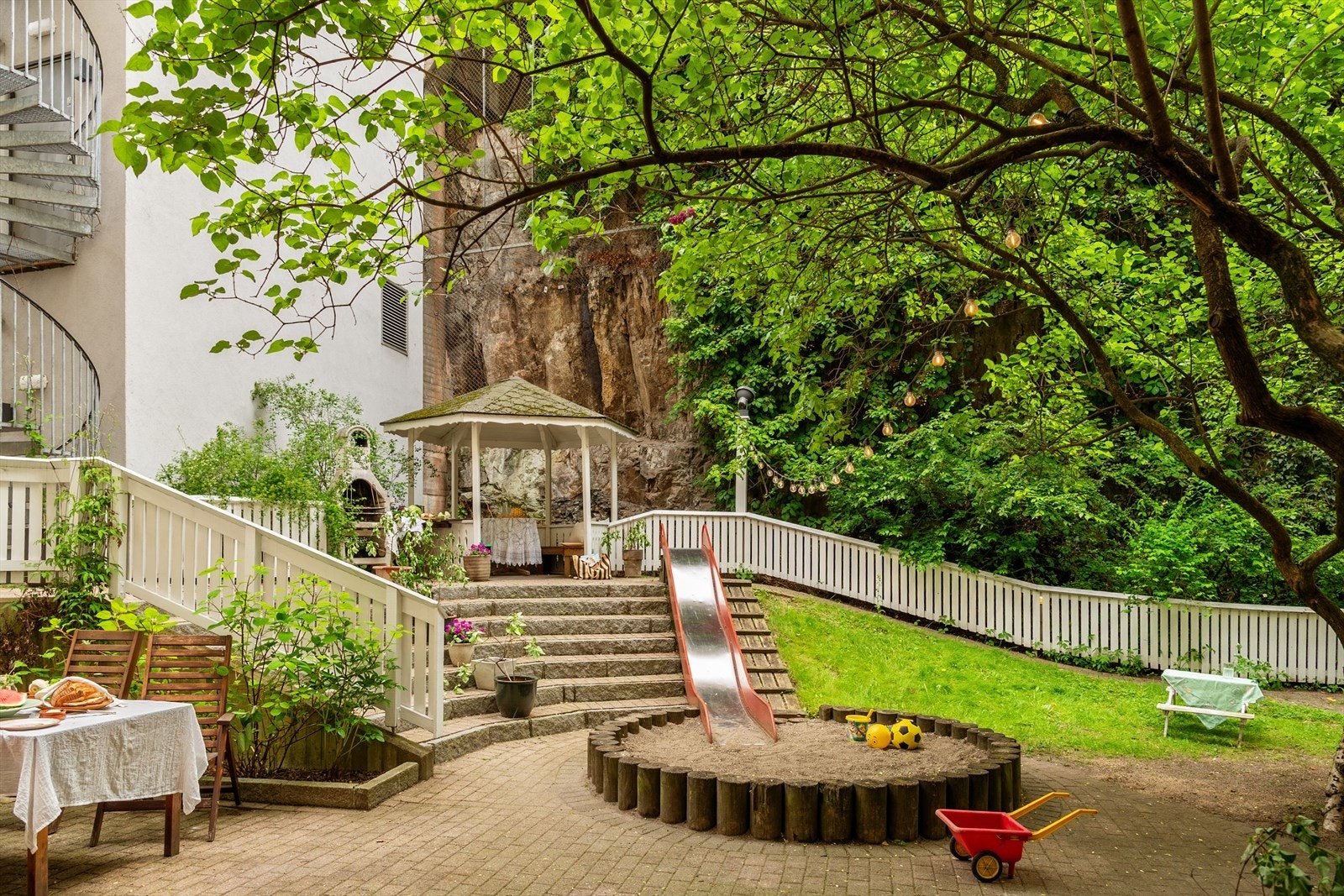 Bakgården er meget pent opparbeidet med flere sittegrupper og plass til at barna kan leke Galleribilde