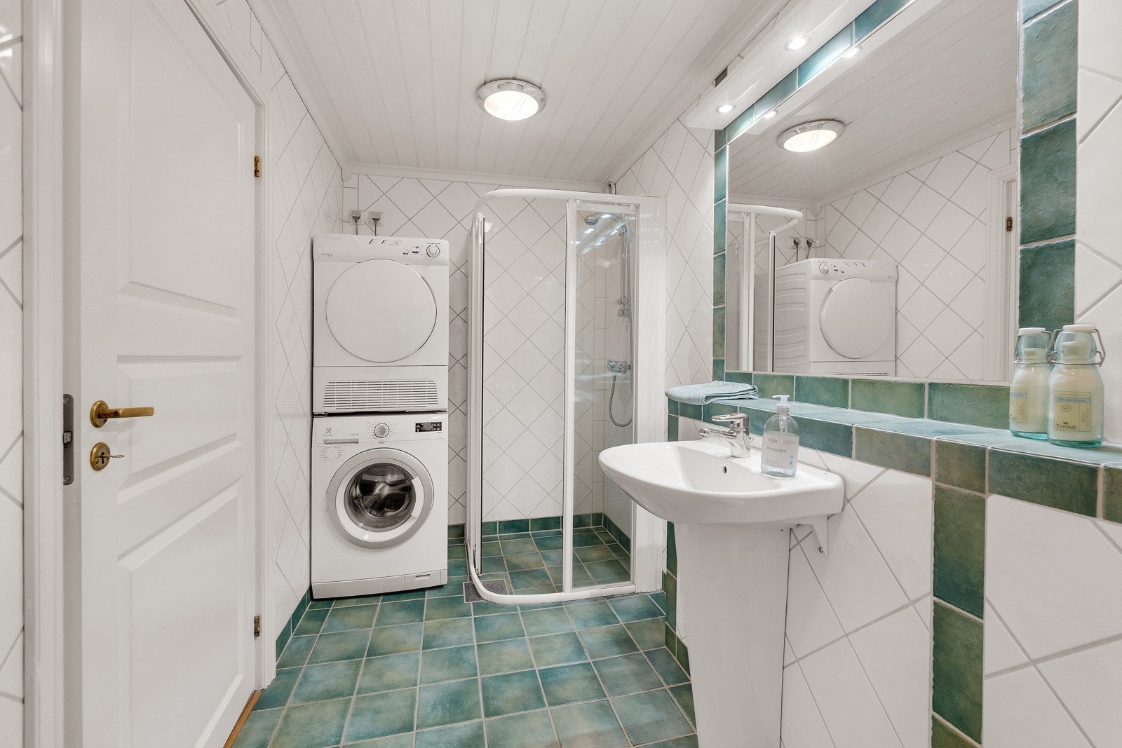 Flislagt baderom fra ca. 2000 med varmekabler. Innredning med servant, veggmontert toalett, dusjvegger/hjørne og opplegg for vaskemaskin Galleribilde