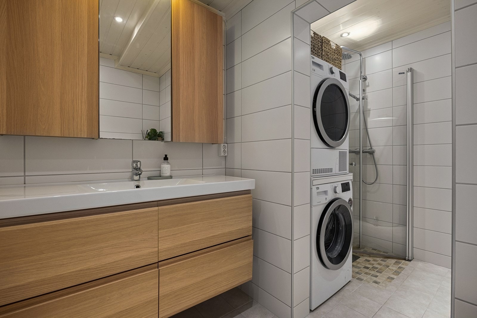 Innredningen består av speil, servant med seksjon, vegghengt toalett, dusjhjørne og opplegg for vaskemaskin. Galleribilde