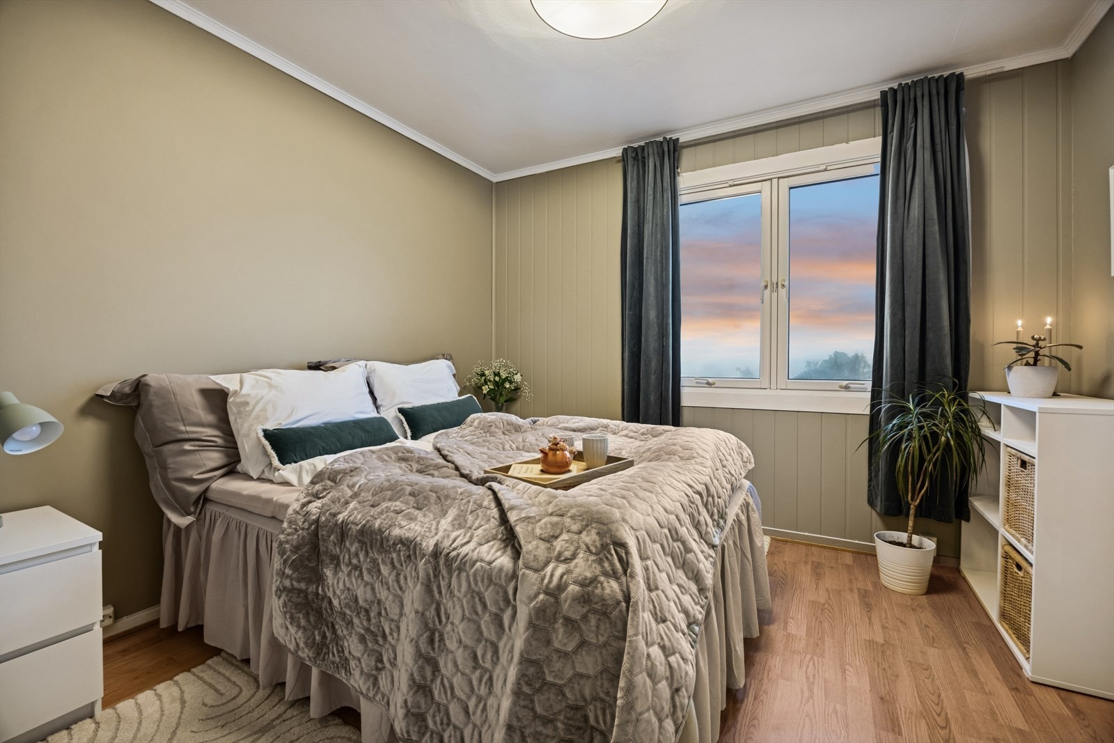 Det er et romslig soverom i leiligheten som er malt i moderne duse farger. Galleribilde