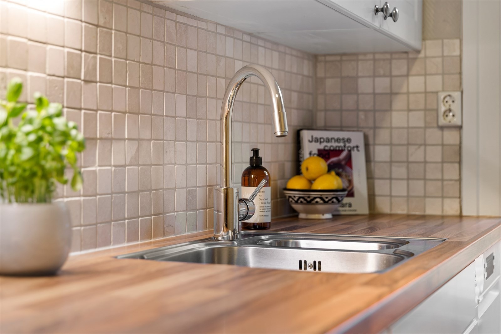 Kjøkkenet er utstyrt med fliser på veggene og moderne blandebatteri. Galleribilde