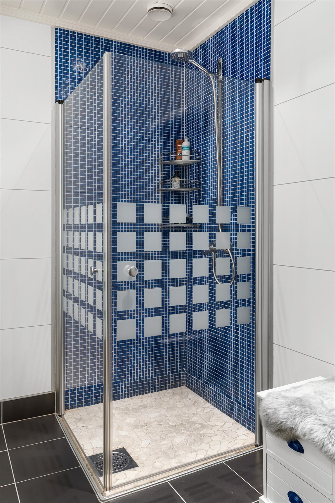 Badet er flislagt på gulv med gulvvarme samt i dusjsone. Baderomsplater på vegger. Galleribilde