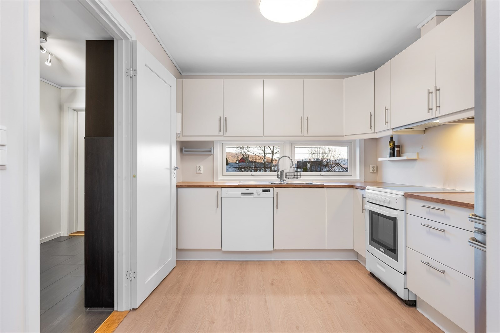 Lyst og stilrent kjøkken. God skap og benkeplass. Galleribilde