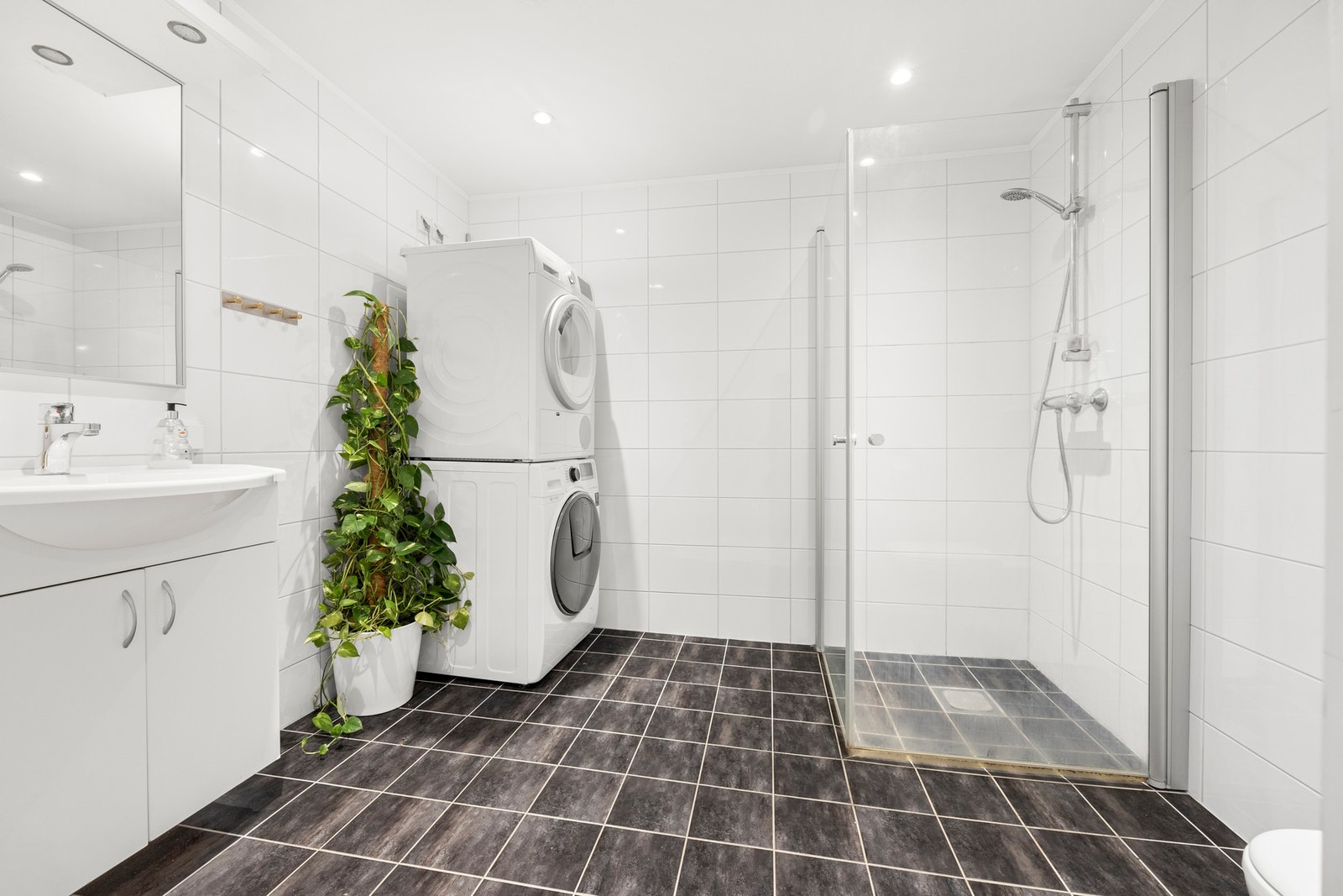 Flislagt baderom med opplegg for vaskemaskin og tørketrommel Galleribilde