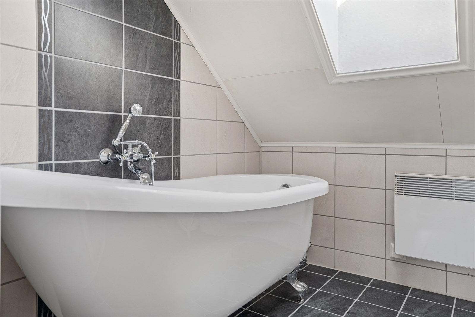 Badet er utstyrt med servantskap med heldekkende servant, gulvmontert toalett og badekar med dusj. Galleribilde