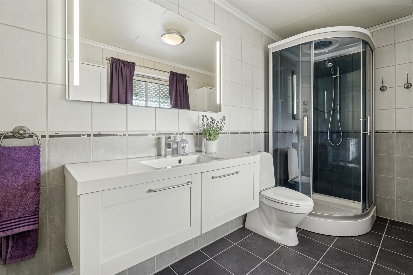 Badet i boligens hovedetasje har flislagt gulv, fliser på vegger og plater i himling. Galleribilde