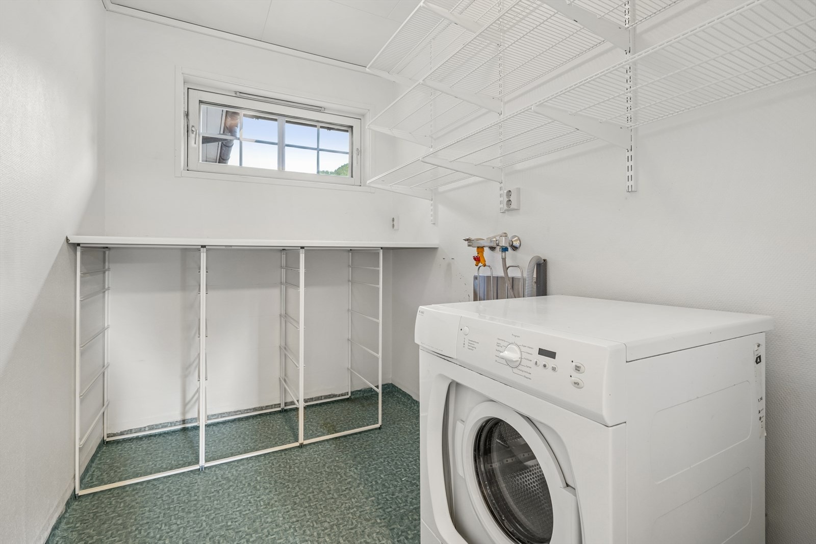 Vaskerommet er praktisk plassert i boligens hovedetasje. Innredningen består av benkeplate og hylleløsninger. Rommet er utstyrt med skyllekar og opplegg vaskemaskin. Galleribilde
