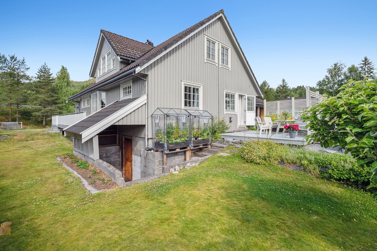 Tomten er pent opparbeidet med plen og beplantninger. Galleribilde