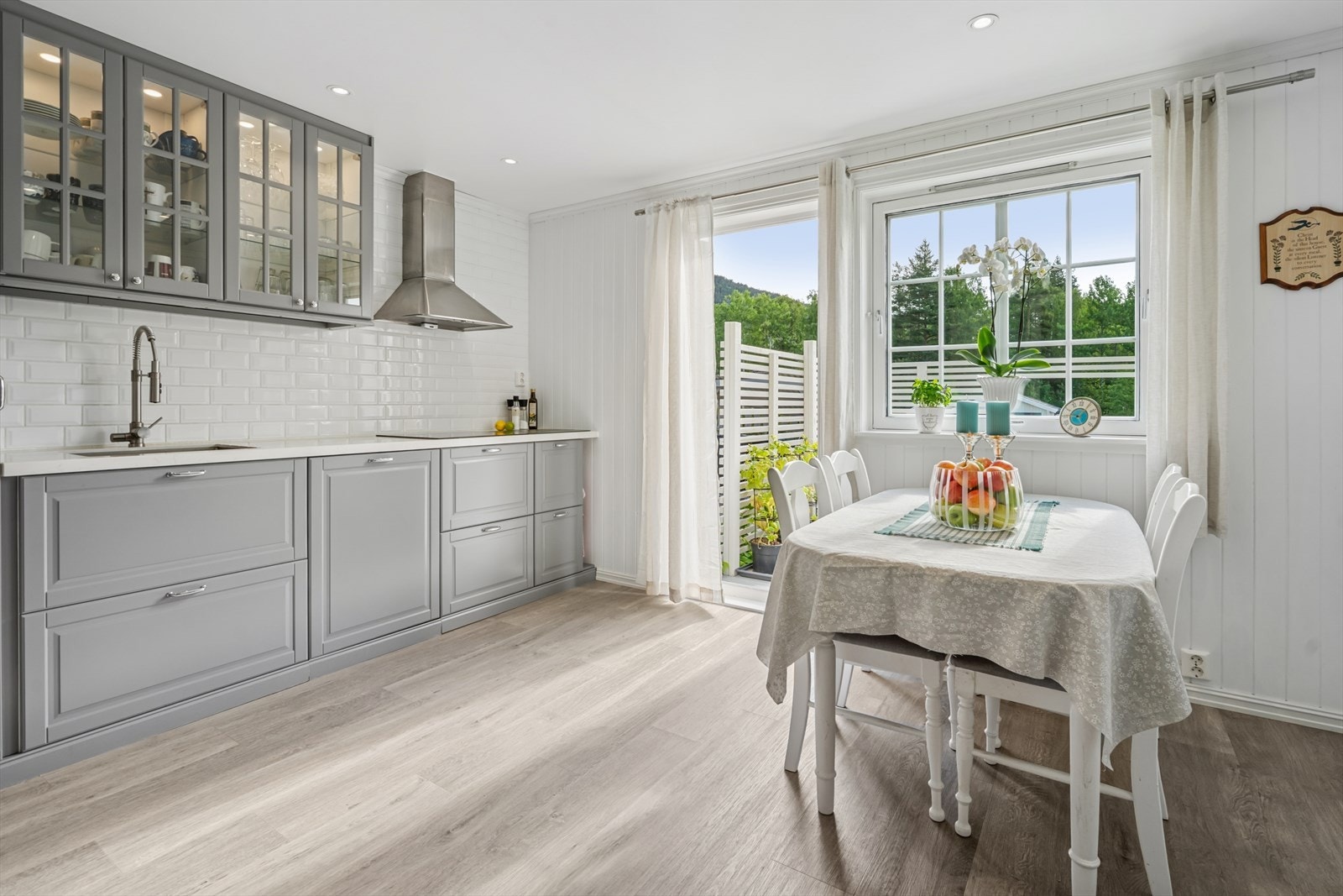 Innredningen har profilerte fronter og glass i overskap, benkeplaten er av kvarts-stein med underlimt oppvaskkum. Galleribilde