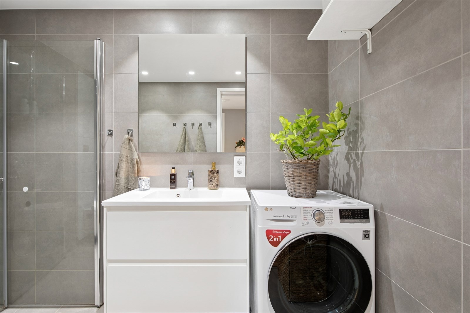 Flislagt baderom med varme i gulv og diverse oppbevaringsmuligheter Galleribilde