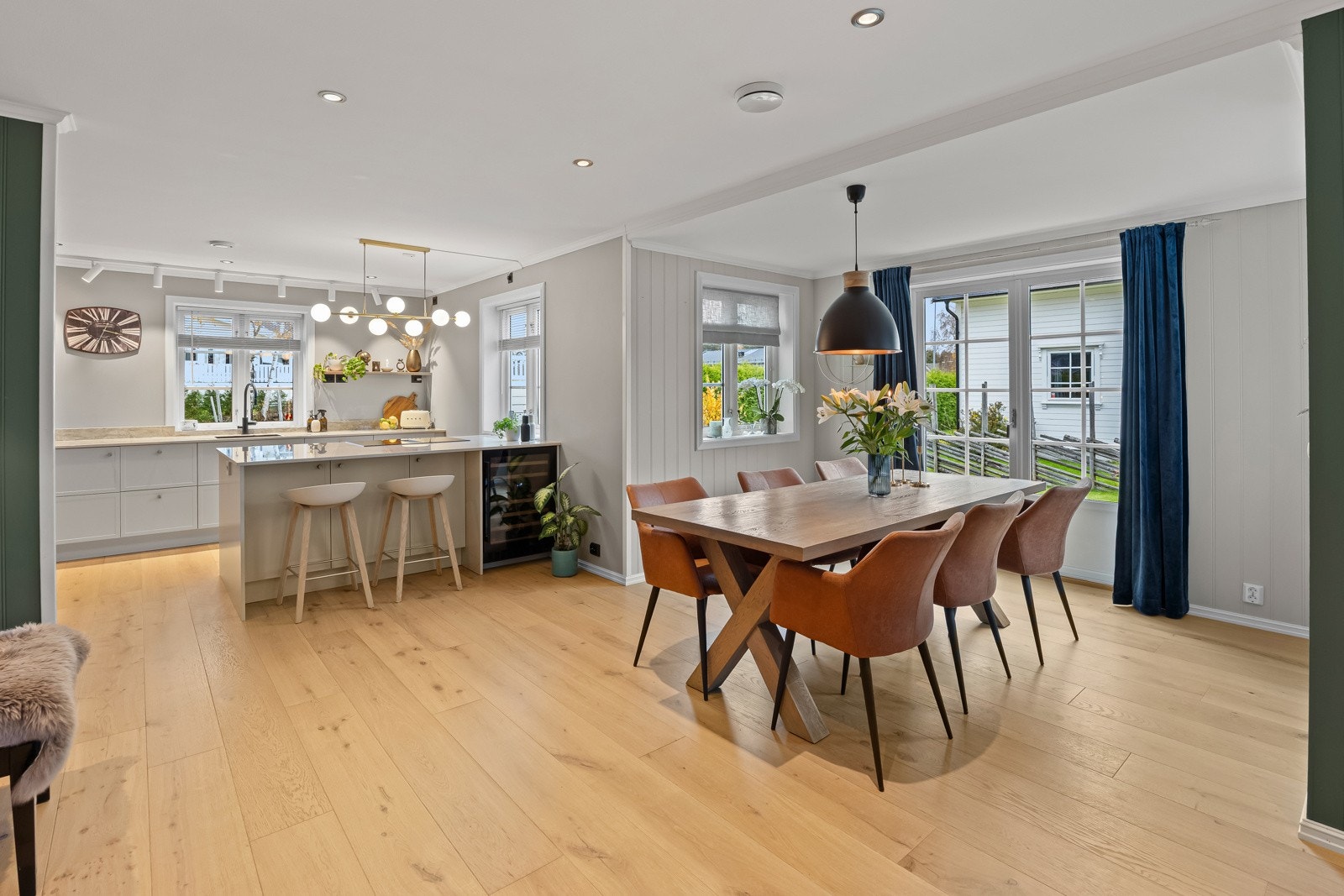 Spisestuen, i forkant av kjøkkenet, innbyr til hyggelige måltider med familie og venner. Flott lys strømmer inn fra store vindusflater som vender direkte mot den velstelte hagen. Galleribilde