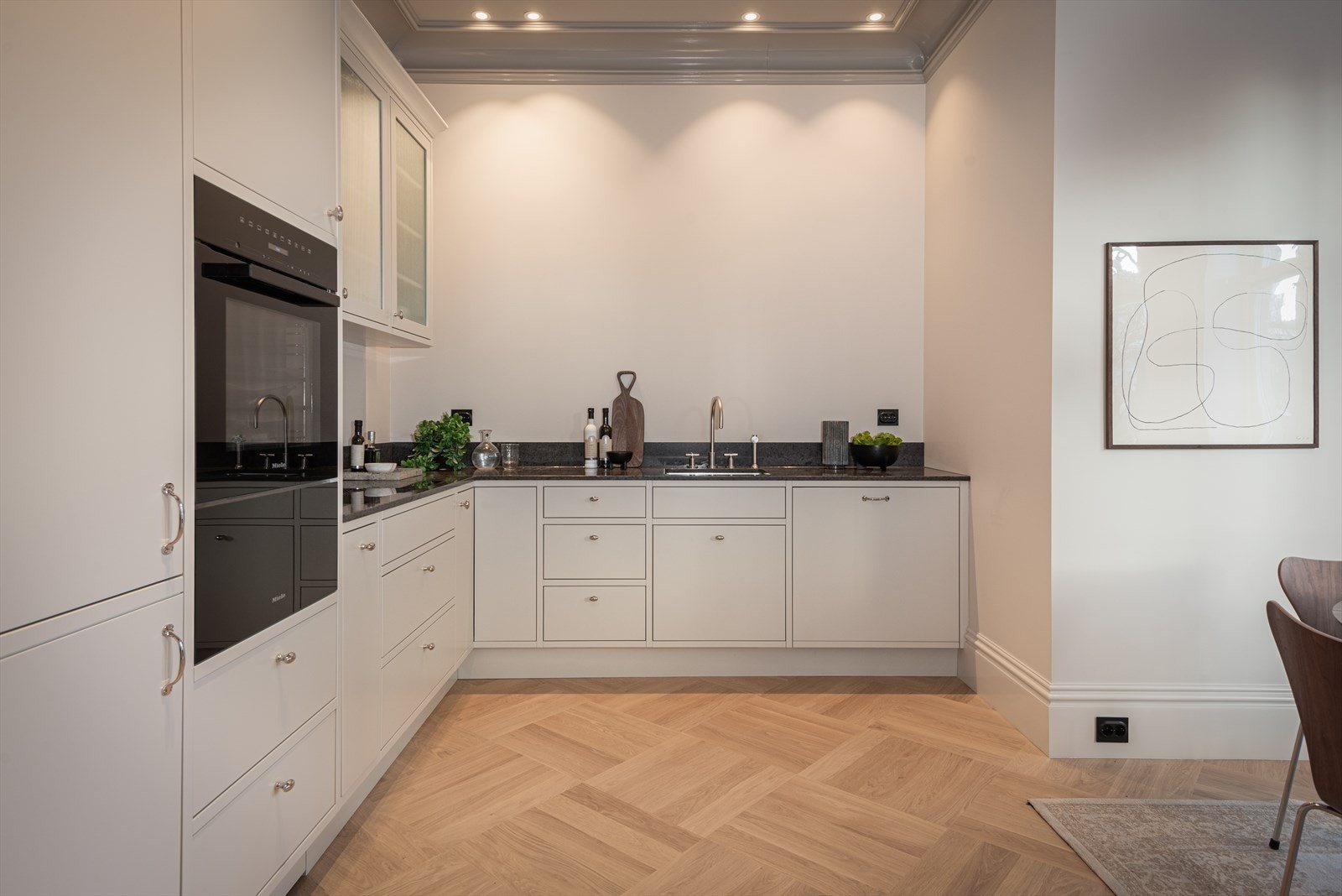 Kjøkkenet har steinbenkeplate, underlimt vask fra Blanco (type Andano 500-U), armatur fra Dornbracht, integrert belysning under overskap, i overskap og innvendig Galleribilde