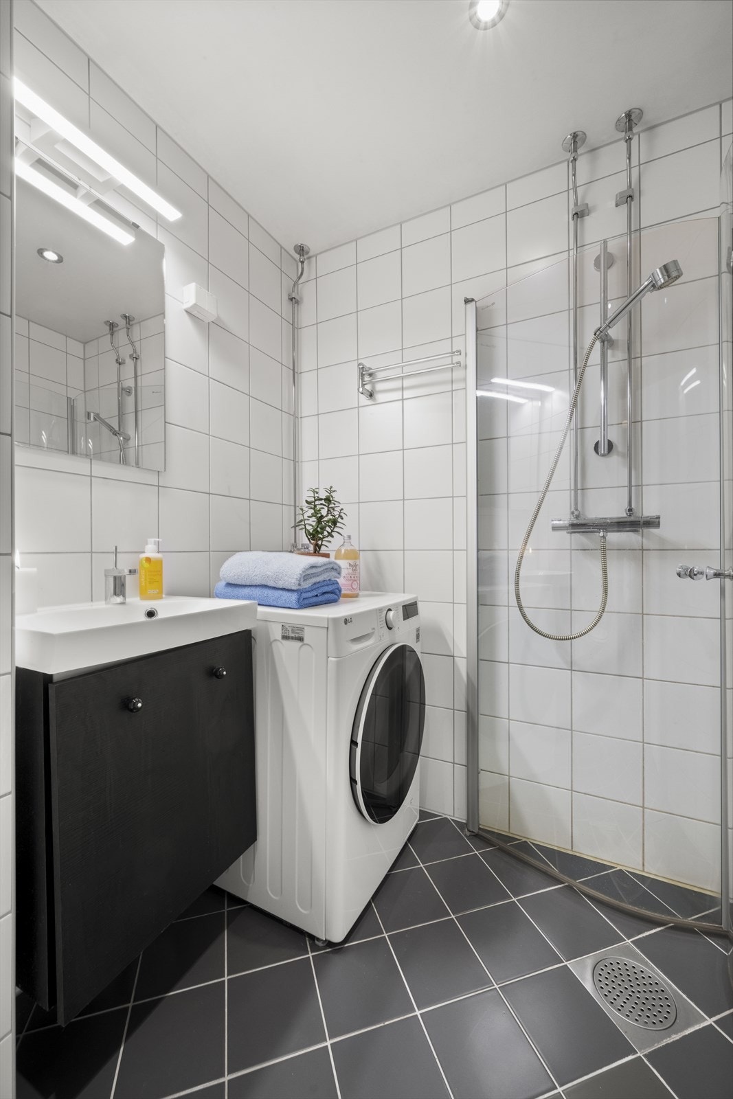 Praktisk innredet med servant nedfelt i innredning, vegghengt klosett og dusjhjørne med svingbare glassdører. Opplegg for vaskemaskin Galleribilde