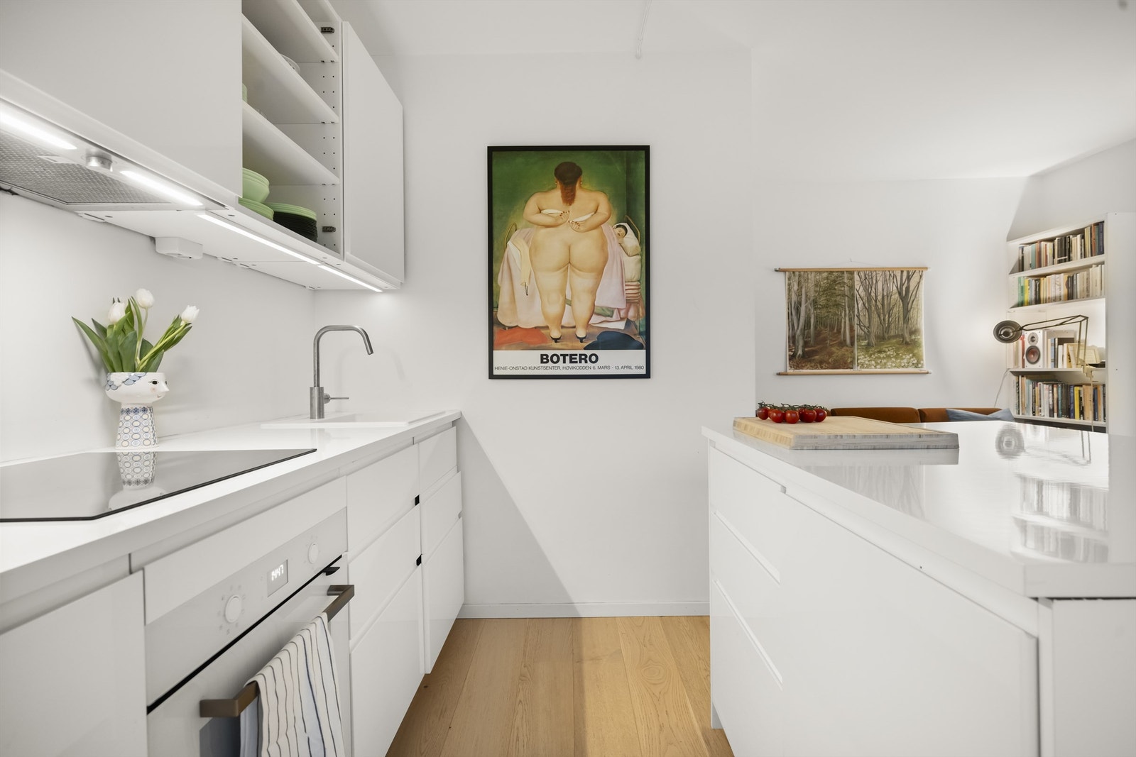 Innredning med glatte fronter og laminat benkeplate med nedfelt vask. Integrert kjøleskap med frys, komfyr og oppvaskmaskin Galleribilde