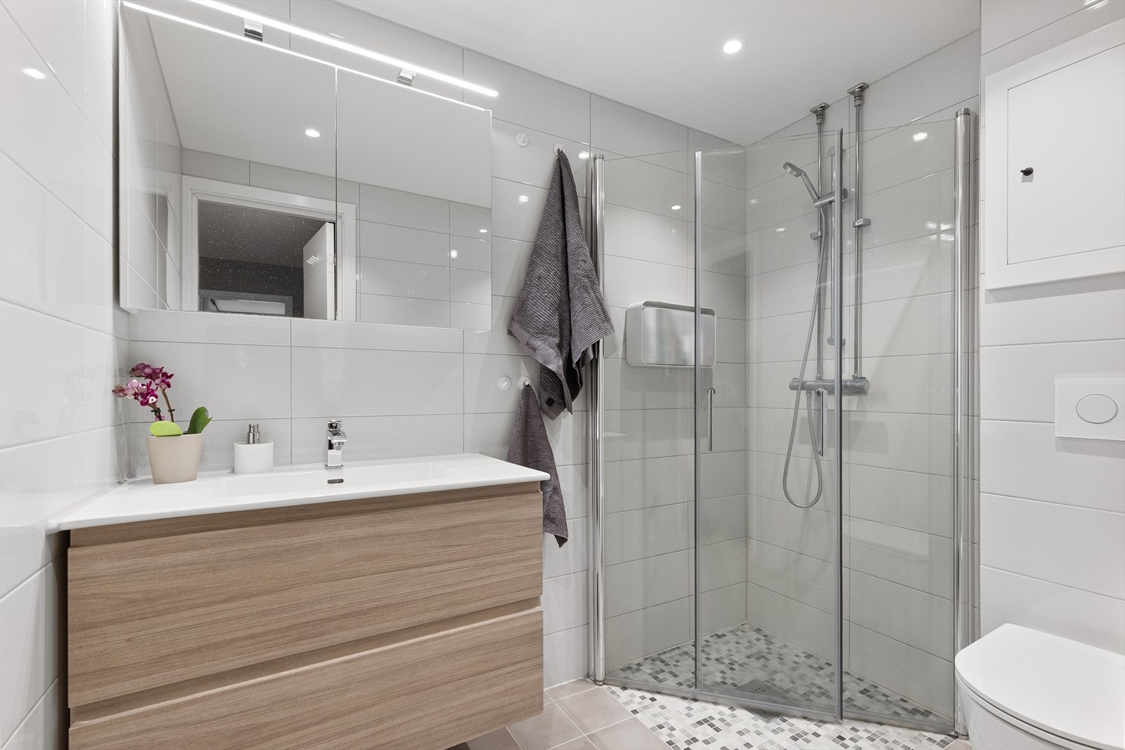 Bad ble rehabilitert i regi av borettslaget i 2020 og har flotte delikate fliser på vegger og gulv. Det er innfelte downlights i himling. Galleribilde